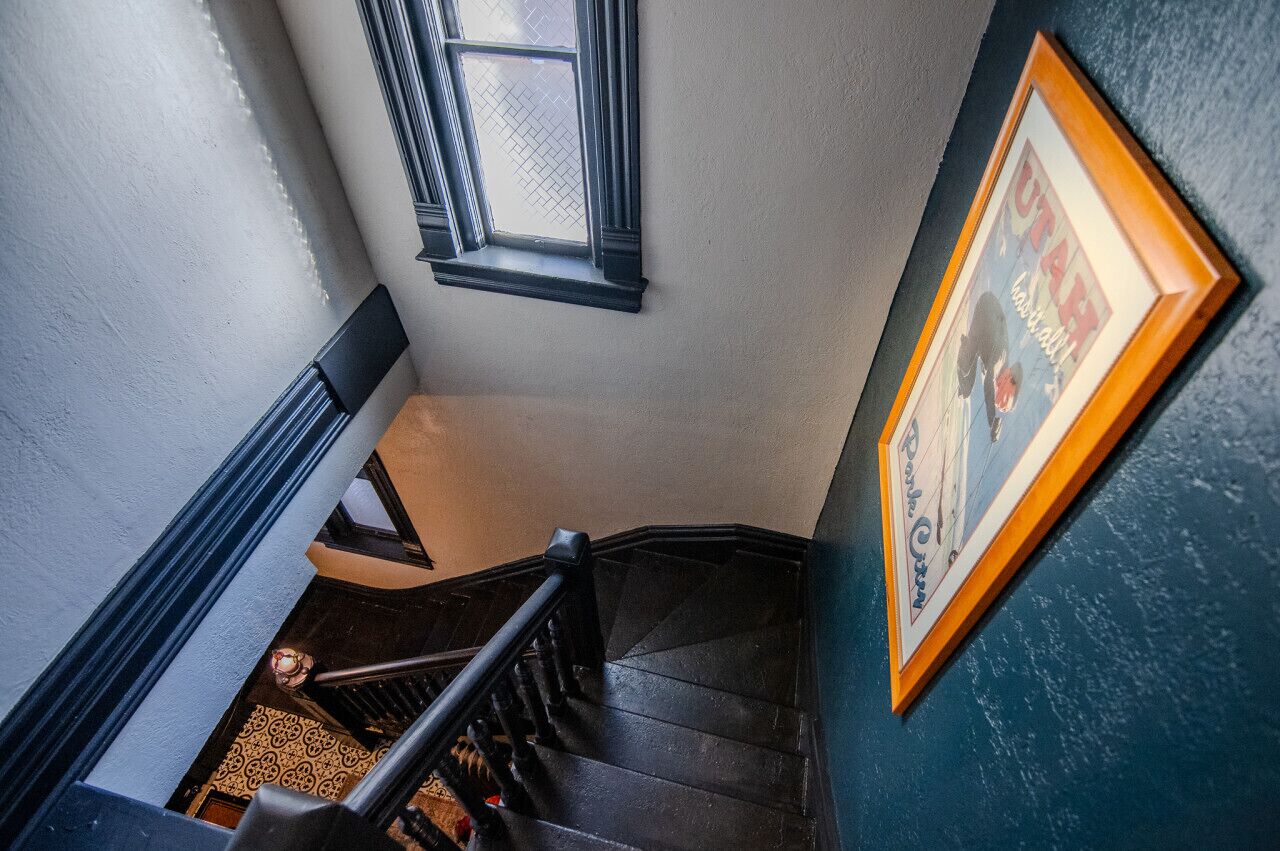 Eine Treppe mit schwarzem Geländer und einem Fenster darüber.