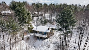 Ein mit Schnee bedecktes Haus, umgeben von Bäumen.