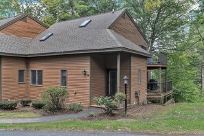 A two-story house with a covered porch, a small deck, and a front yard with landscaping. - Hot Tub, Sauna, Comm. Pool, Club - Deere Run 6A (Quechee)