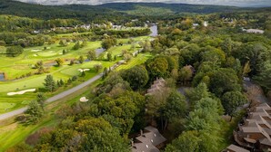 A golf course with a river, surrounded by dense forest and residential buildings. - Condo with Hot Tub & Private Sauna, Deere Run (Quechee)
