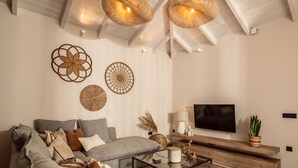 Un salon moderne avec un canapé d’angle, une table basse et des œuvres d’art décoratives au mur.
