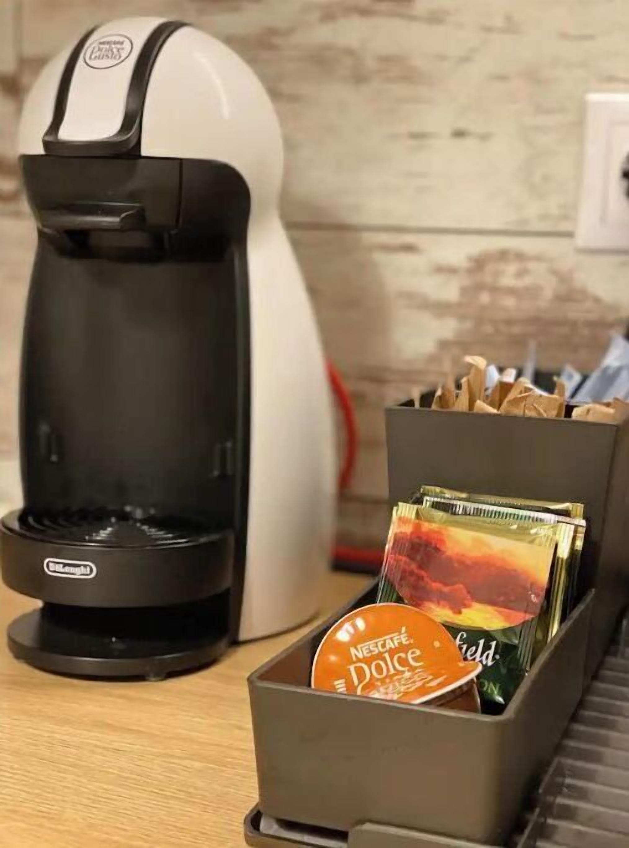 Una máquina de café Nescafe Dolce Gusto con un portacapsulas que contiene cápsulas Nescafe Dolce Gusto.