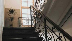 Eine Treppe mit aufwendiger schwarzer Geländer und einer Chandelüster.
