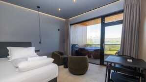 A modern hotel room with a bed, a desk, and a chair. - North Mountain View Suites (Akureyri)