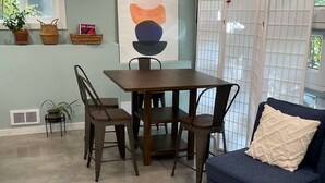 A dining area with a table and chairs, a sofa, a rug, and a bookshelf. - West Seattle Hideaway, 5 min from downtown/stadiums (Seattle)