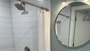 A bathroom with a shower, a sink, and a mirror. - West Seattle Hideaway, 5 min from downtown/stadiums (Seattle)