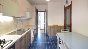 A compact kitchen with a sink, stove, and washing machine. - Lovely apartment in Recco (Recco)