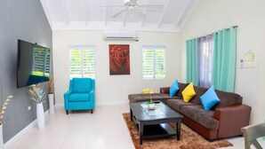 Una sala moderna con sofá, sillón y mesa de centro.