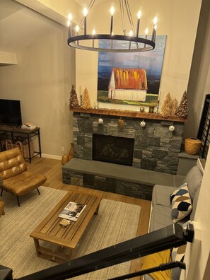 TV connectée, cheminée, livres, chaîne hi-fi