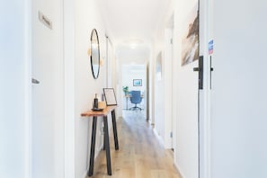Un couloir avec un bureau, un miroir et une porte portant l’inscription « Privé ».
