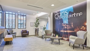 Um hall com assentos, um grande cartaz de Montmartre, Paris, e uma escadaria.