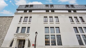 A white building with the sign "ODALYS CITY" at the entrance. - Studio 20m2 dans résidence avec services hôteliers (Paris)