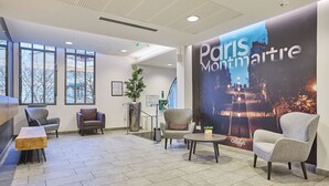 A lobby with seating, a large poster of Paris Montmartre, and a staircase. - Studio 20m2 dans résidence avec services hôteliers (Paris)