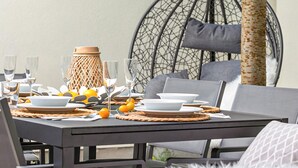 Een eettafel gedekt met borden, glazen en een decoratief middelpunt.