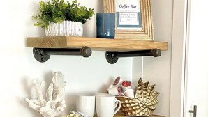 Eine Küche mit zwei Holzböden, auf denen ein Schild für eine Kaffeebar, ein Blumentopf und verschiedene Küchenutensilien stehen. Darunter befindet sich eine Kaffeemaschine auf der Arbeitsplatte.