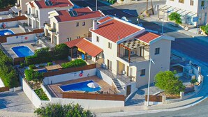 A modern residential building with a rooftop pool, balconies, and a covered outdoor area. - Villa Lefkas in Malatya (Meladeia)