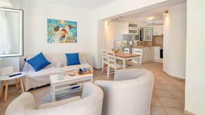 A modern living room with a sofa, two armchairs, a coffee table, and a painting on the wall. - Doras House in Gaios (Paxos)