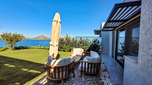 A patio with outdoor furniture, a pergola, and a view of the sea. - Çimentepe Residence Deluxe (Bodrum)
