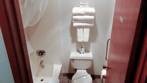 Ein kleines, kompaktes Badezimmer mit Toilette, Waschbecken und Duschbereich.