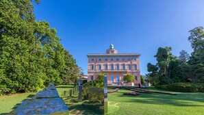 A large, pink building with a central tower, surrounded by well-maintained lawns and trees. - Heart of Lugano in Lugano (Lugano)