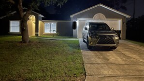 Uma casa com entrada por automóvel, garagem e uma árvore.
