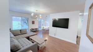 A modern living room with a sofa, a coffee table, and a TV mounted on the wall. - Stunning 3 bedroom single family home. (Windsor)