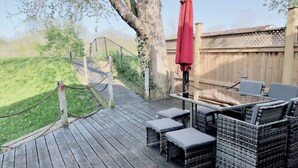 A wooden deck with wicker furniture and a red umbrella. - Stunning 3 bedroom single family home. (Windsor)
