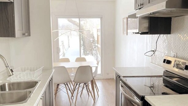 A modern kitchen with a dining area, stainless steel appliances, and a view of the outdoors. - Stunning 3 bedroom single family home. (Windsor)