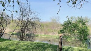 A wooden deck overlooking a pond with trees and grass. - Stunning 3 bedroom single family home. (Windsor)