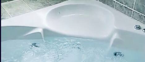 Een douche, een bubbelbad, handdoeken, toiletpapier