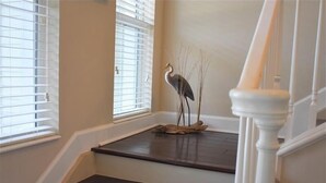 A staircase with a bird sculpture on the landing.