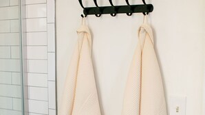 Une salle de bain avec un porte-serviettes sur lequel sont posées deux serviettes.