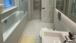 Ein modernes Badezimmer mit Badewanne, Dusche, Waschbecken und Toilette.
