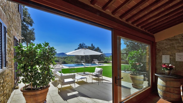 A patio with outdoor furniture, a swimming pool, and a view of the landscape.
