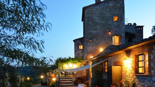 A stone building with a stone staircase leading to a covered outdoor seating area. - Torre Del Melograno With Heated Pool (Castiglione in Teverina)