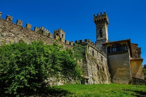 A historic stone castle with multiple towers and a large arched window. - La Badia 1 in Tavarnelle Val di Pesa (Barberino Tavarnelle)