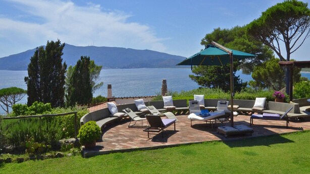A patio with outdoor seating and a view of the sea. - Villa Ada in Ansedonia (Orbetello)