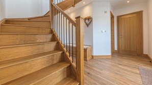 A wooden staircase with black railings leading to a landing. - Old Stable (Ulverston)