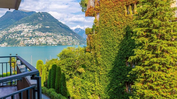 A balcony with a view of a lake, mountains, and a cityscape. - Coloratura in Paradiso Lugano (Paradiso)