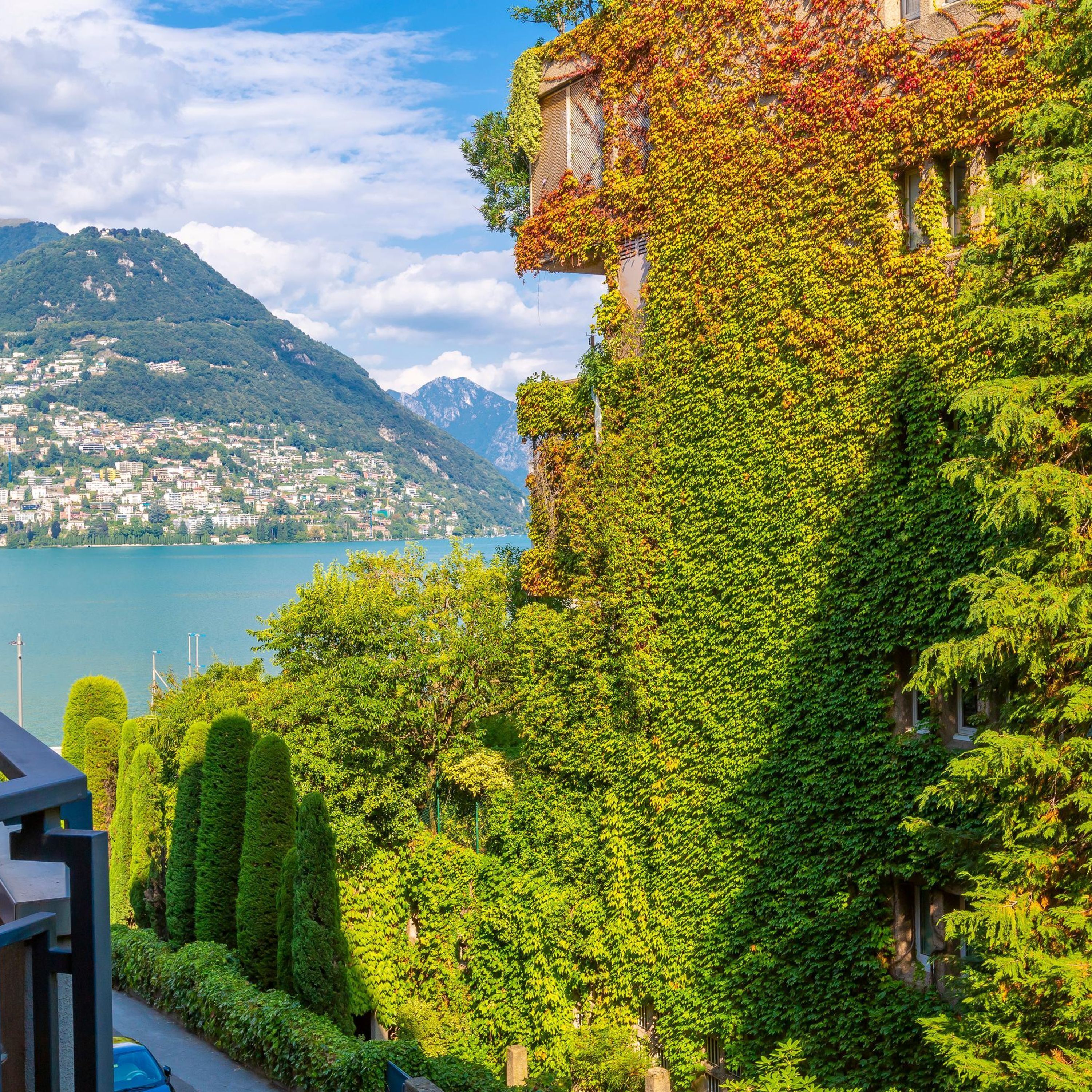 A hillside building with a view of a lake and mountains.