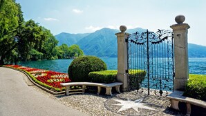 A paved pathway leading to a gate with a star-shaped pattern on the ground. - Coloratura in Paradiso Lugano (Paradiso)