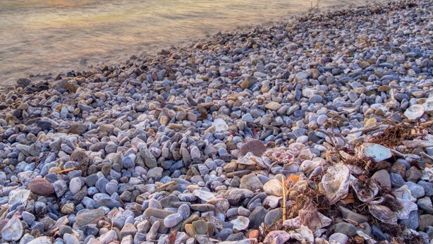 A pebbled beach with a sunset in the background. - Panorama Seaview Kolomban (Koper)