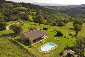 A stone house with a tiled roof, a swimming pool, and a garden with a gazebo. - Villa Borgiano in Scansano (Scansano)
