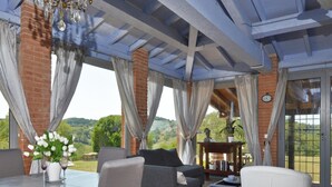 A covered outdoor seating area with a dining table, chairs, and a sofa. - Villa Borgiano in Scansano (Scansano)