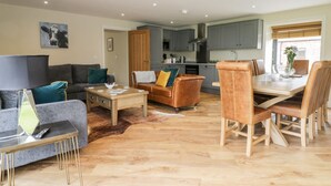 A modern living room with a sofa, coffee table, and dining area. - Partridge Place (Hull)
