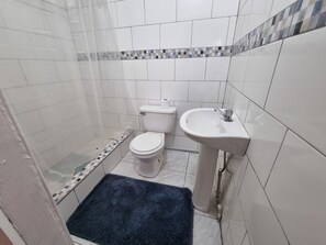 A bathroom with a shower, toilet, and sink. - Leisure Duplex At Csompo Silver Manor (Tower Isle)