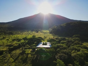 A mountain with a clear sky and a building in the foreground. - Stunning Volcano View • Private Pool • Near Hot Springs • Pet Friendly (Mogote de Bagaces)
