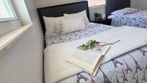 A bedroom with a bed, a window, a nightstand, and a small plant. - Busch Gardens Deluxe Edition w/heated pool (Tampa)