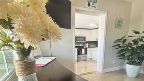 A kitchen area with white cabinets, a microwave, and a stove. There is a vase with white flowers on a counter. - Busch Gardens Deluxe Edition w/heated pool (Tampa)