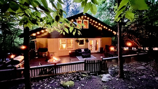 A cozy cabin with a porch, string lights, and a fire pit. - Storybook Chalet/Watch Movies Under the Stars/NEW Hot Tub/Hiking/Biking/Concerts (Beech Mountain)